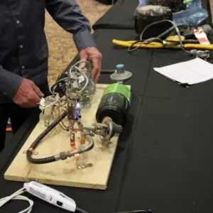 Person examining mechanical device on a table.