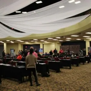 Conference room with attendees under white fabric drapes.