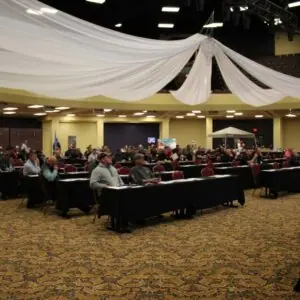 Conference attendees seated in large event hall.