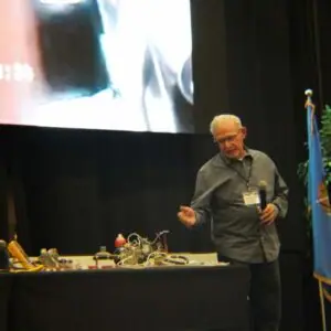 Man giving a presentation with equipment on the table.