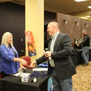 People interacting at booth during networking event.