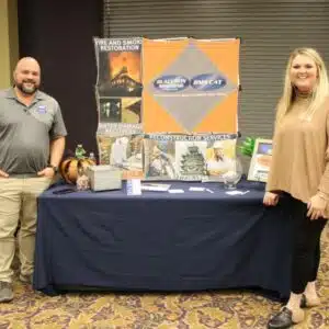 Two people at a fire restoration service booth.