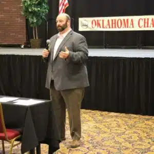 Speaker at Oklahoma chapter event with microphone.